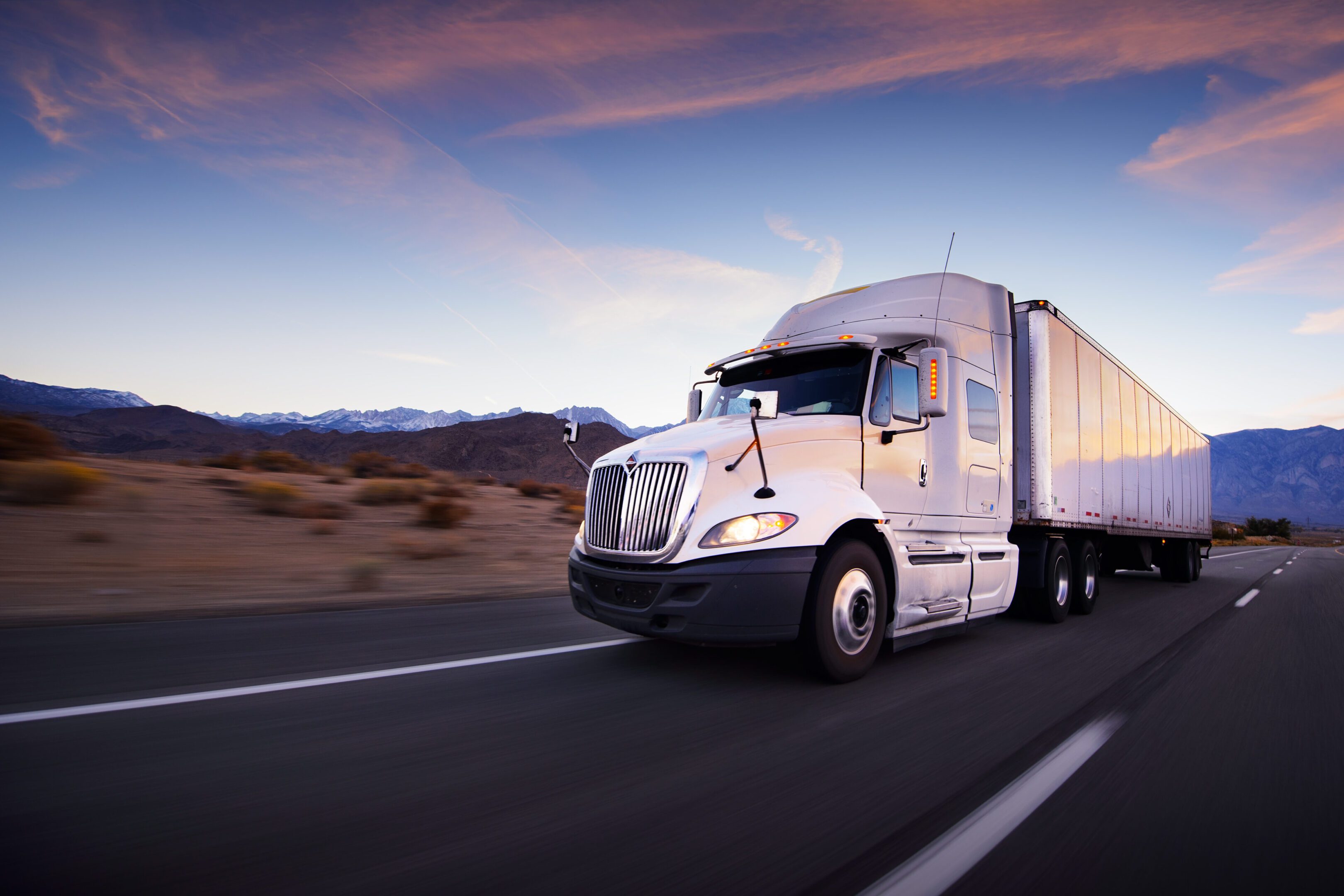 White semi-truck driving on open highway.